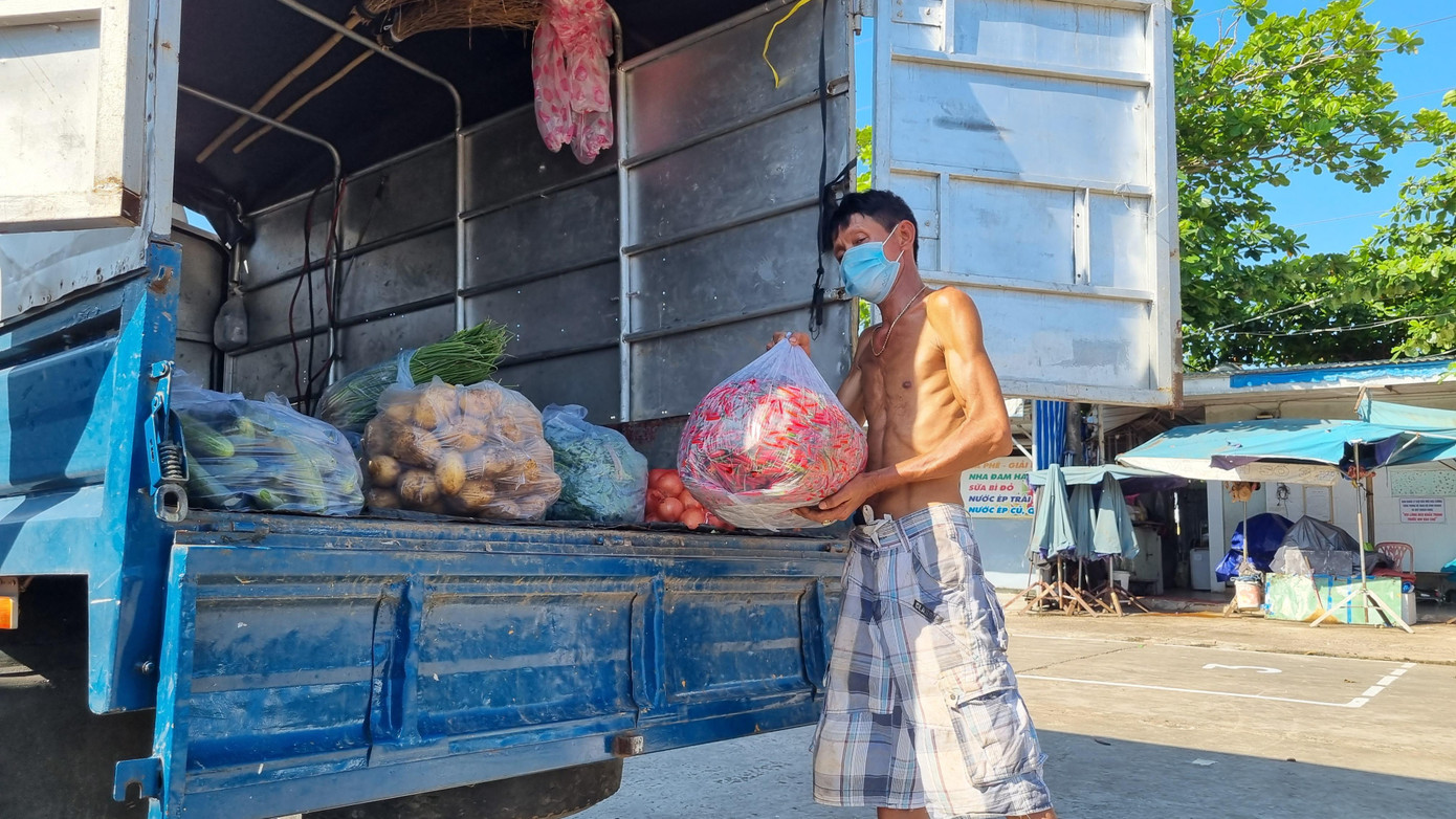 Hàng hóa nhập về vào cổng chợ, xuống hàng trong sân, không chuyển vào điểm kinh doanh trong chợ và được đội bốc xếp đưa lên xe tải nhỏ để vận chuyển ra khỏi chợ. - Ảnh Thanh Trần. Hàng hóa nhập về vào cổng chợ, xuống hàng trong sân, không chuyển vào điểm kinh doanh trong chợ và được đội bốc xếp đưa lên xe tải nhỏ để vận chuyển ra khỏi chợ. - Ảnh Thanh Trần.