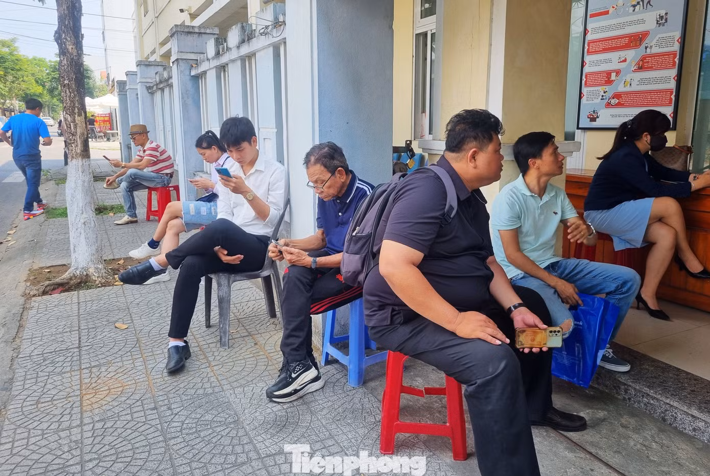 Do thời tiết nắng nóng, phải chờ đợi nhiều tiếng đồng hồ nên UBND quận bố trí ghế cho người dân ngồi. Lượng người quá đông, phía trong nhà hết chỗ, người dân phải ngồi đợi trên vỉa hè.