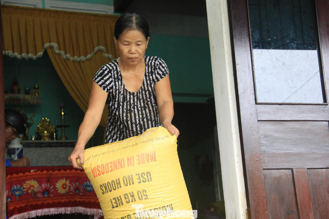 Trước khi di tản, bà Đặng Thị Mẫn kéo mấy tạ lúa đến nơi cao ráo vì lo mưa bão sẽ gây ngập lụt.