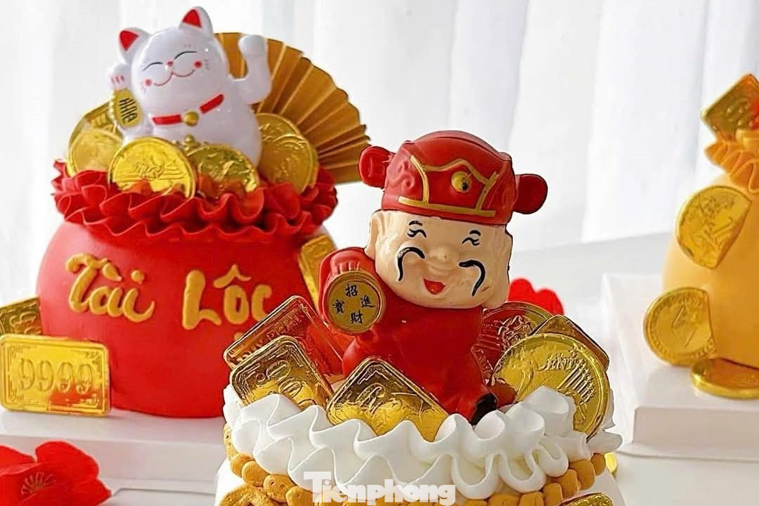 Quanh bánh đính thêm ông Thần tài, mèo Thần tài, đồng xu, tiền đô… Khách cũng có thể yêu cầu trang trí theo nhu cầu. Giá bán mỗi chiếc bánh tùy kích cỡ từ 150.000 - 400.000 đồng. Quanh bánh đính thêm ông Thần tài, mèo Thần tài, đồng xu, tiền đô… Khách cũng có thể yêu cầu trang trí theo nhu cầu. Giá bán mỗi chiếc bánh tùy kích cỡ từ 150.000 - 400.000 đồng.