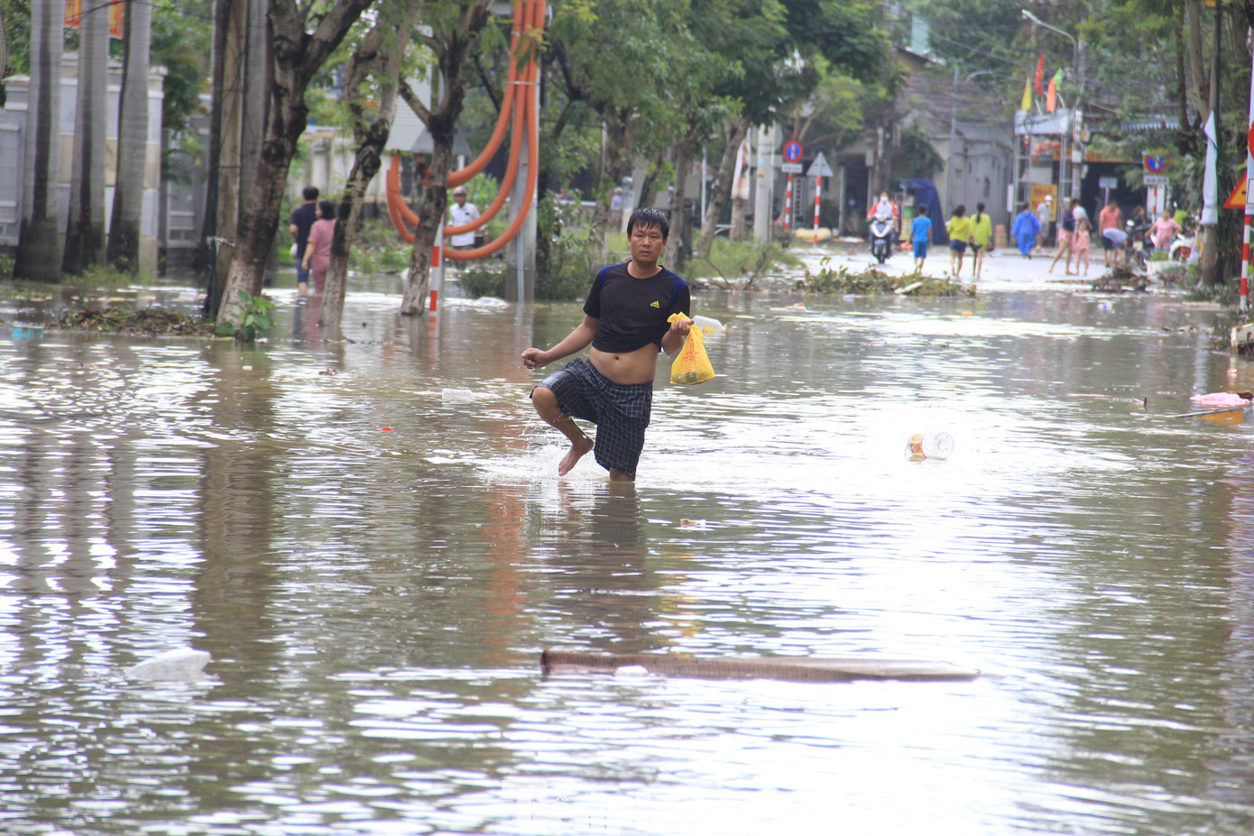 Xe cộ không thể qua lại, người dân lội nước đi mua đồ ăn.