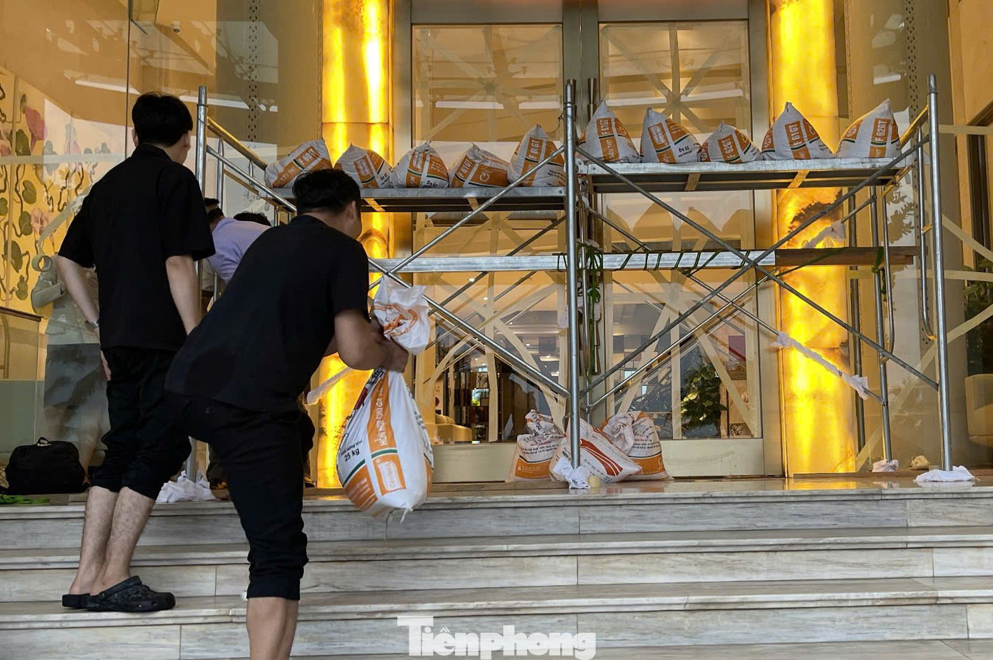 Khung sắt, bao cát bảo vệ cửa kính. Khung sắt, bao cát bảo vệ cửa kính.