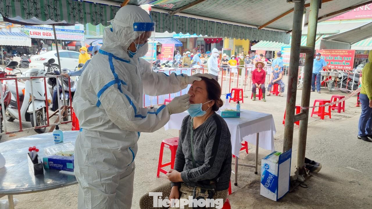 Nhân viên y tế lấy mẫu xét nghiệm cho tiểu thương chợ Cẩm Lệ - nơi liên quan đến lịch trình di chuyển của một ca dương tính. Ảnh: Thanh Trần. Nhân viên y tế lấy mẫu xét nghiệm cho tiểu thương chợ Cẩm Lệ - nơi liên quan đến lịch trình di chuyển của một ca dương tính. Ảnh: Thanh Trần.