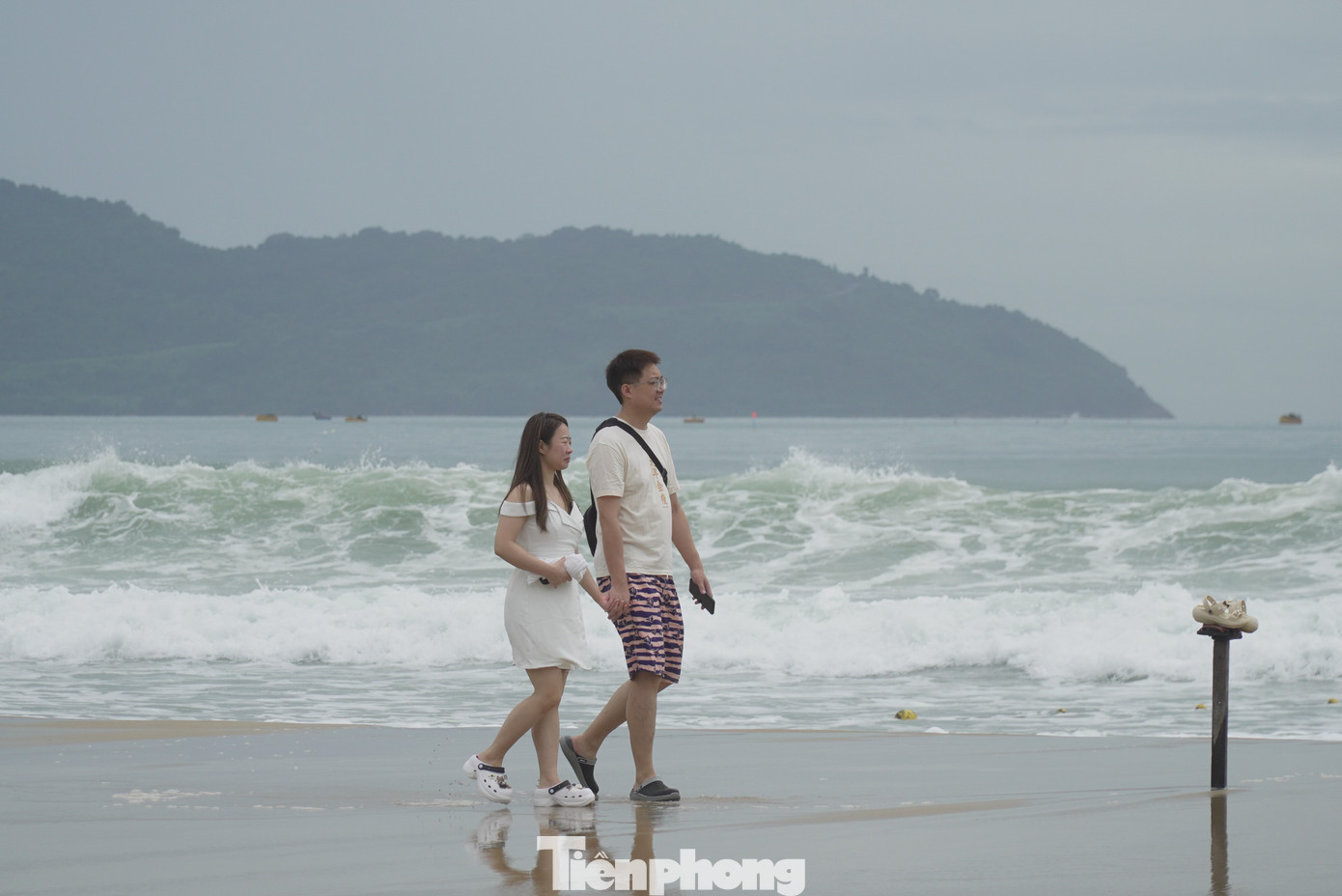 Sóng biển khá cao, du khách đi bộ dọc biển. Trong sáng nay, lúc 9h bão số 4 mạnh cấp 8, giật cấp 11, cách đảo Cồn Cỏ (Quảng Trị) khoảng 90km về phía đông, cách Quảng Trị khoảng 120km. Ảnh: Thanh Hiền.