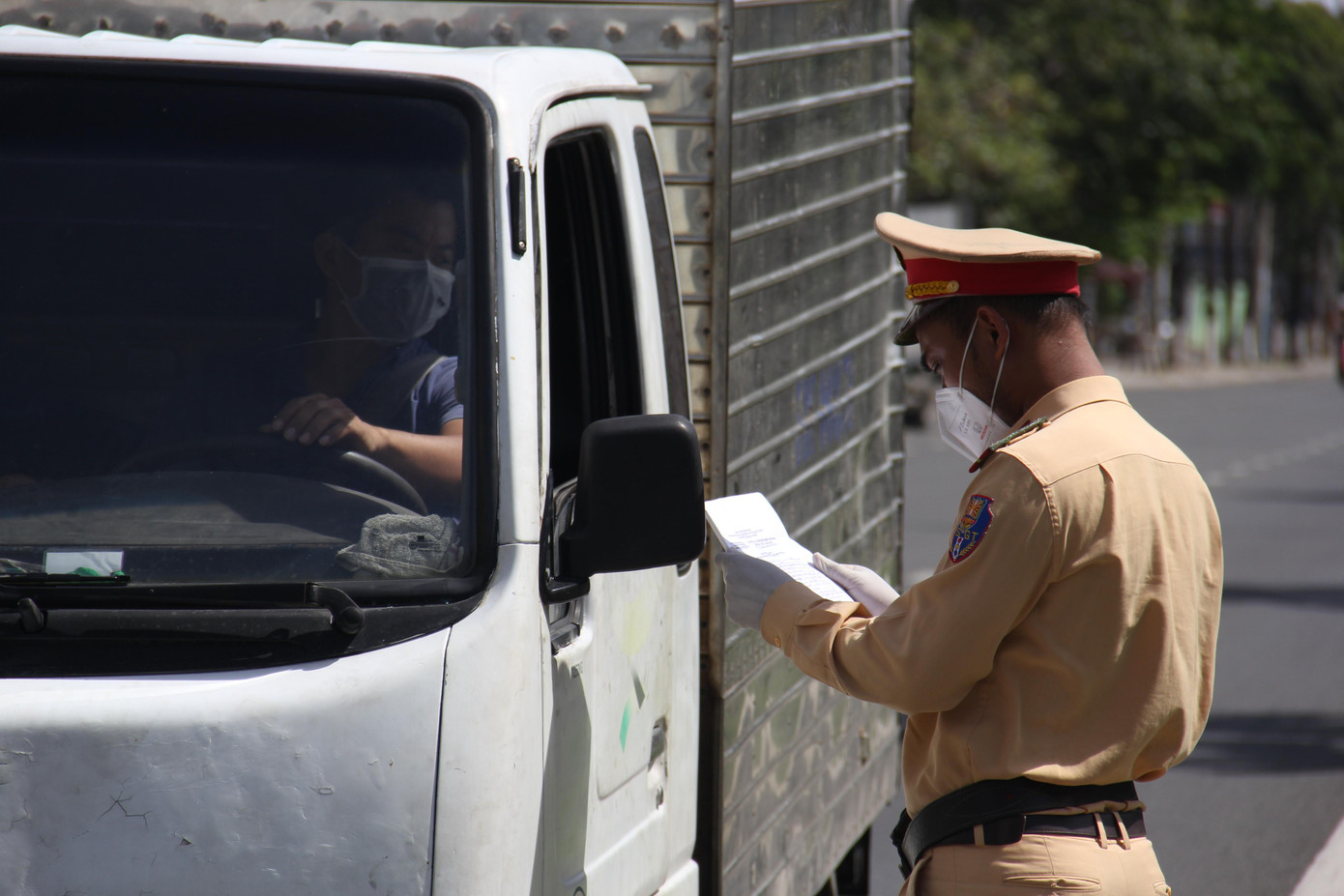 Tài xế xe hàng xuất trình giấy tờ với CSGT khi qua chốt kiểm soát. Tài xế xe hàng xuất trình giấy tờ với CSGT khi qua chốt kiểm soát.