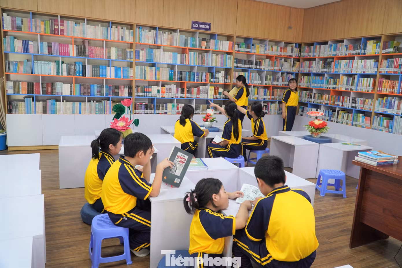 Học sinh có thể thoải mái ngồi đọc sách ở bàn ghế hoặc tựa lưng vào tường. Gia Linh (lớp 6/7) chia sẻ: "Ở đây thoải mái như quán cà phê, nhà sách nên em rất thích tới. Hơn nữa góc nào trong thư viện cũng "chill". Các thầy cô giáo cho hay, một số tiết học cần thay đổi không gian hoặc cần tìm kiếm nhiều tư liệu, giáo viên sẽ đưa lớp xuống thư viện học. Ảnh: Thanh Hiền.