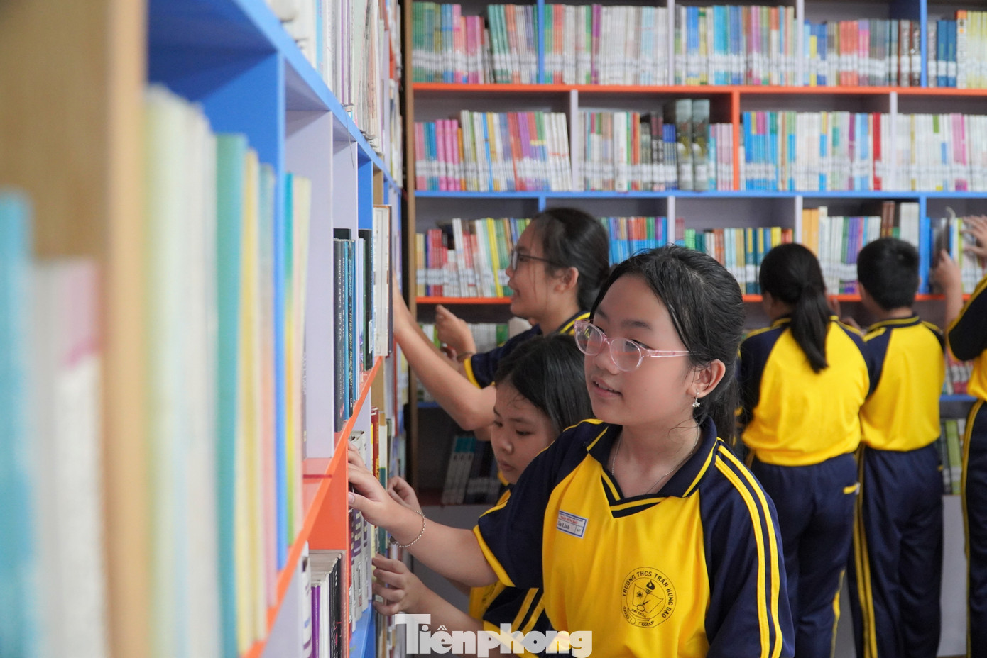 Học sinh có thể thoải mái ngồi đọc sách ở bàn ghế hoặc tựa lưng vào tường. Gia Linh (lớp 6/7) chia sẻ: "Ở đây thoải mái như quán cà phê, nhà sách nên em rất thích tới. Hơn nữa góc nào trong thư viện cũng "chill". Các thầy cô giáo cho hay, một số tiết học cần thay đổi không gian hoặc cần tìm kiếm nhiều tư liệu, giáo viên sẽ đưa lớp xuống thư viện học. Ảnh: Thanh Hiền.