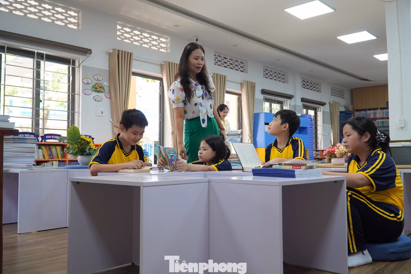 Học sinh có thể thoải mái ngồi đọc sách ở bàn ghế hoặc tựa lưng vào tường. Gia Linh (lớp 6/7) chia sẻ: "Ở đây thoải mái như quán cà phê, nhà sách nên em rất thích tới. Hơn nữa góc nào trong thư viện cũng "chill". Các thầy cô giáo cho hay, một số tiết học cần thay đổi không gian hoặc cần tìm kiếm nhiều tư liệu, giáo viên sẽ đưa lớp xuống thư viện học. Ảnh: Thanh Hiền.