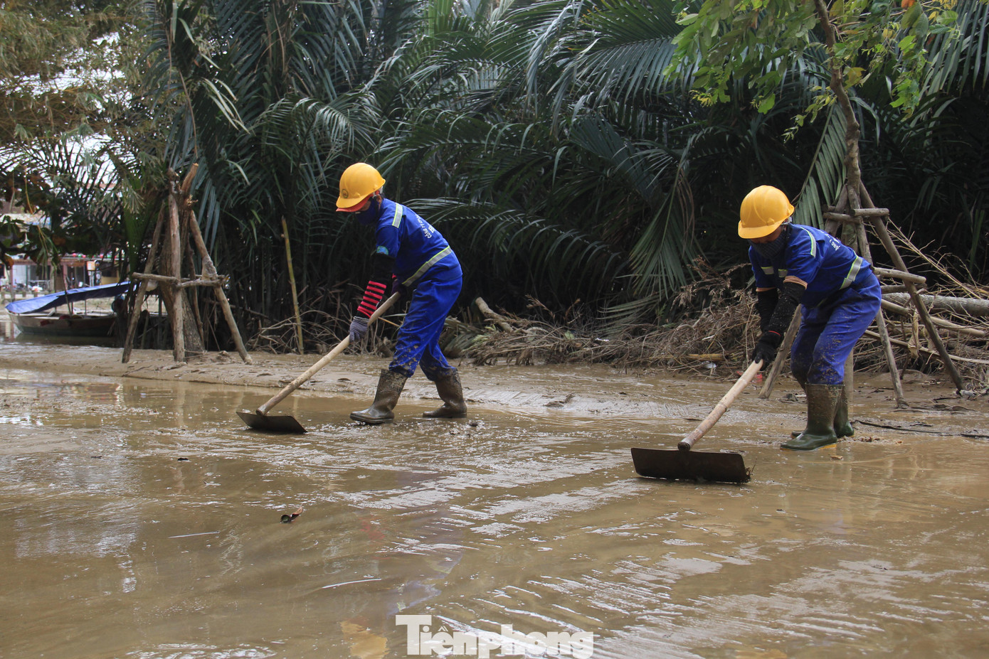 Bùn nòn bám dày cả mặt đường, công nhân phải dùng cào đẩy. Bùn nòn bám dày cả mặt đường, công nhân phải dùng cào đẩy.