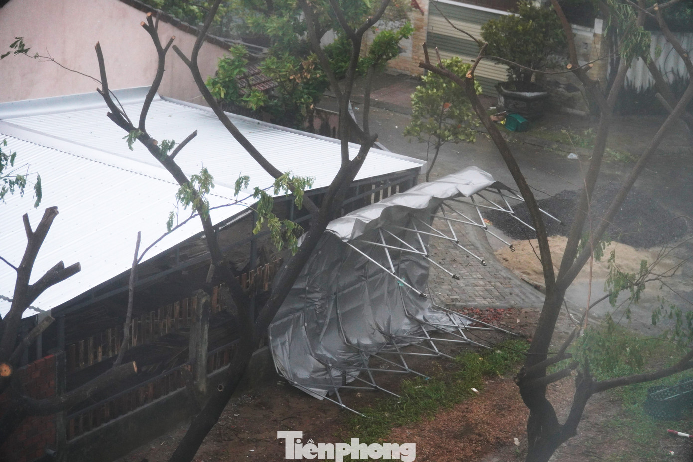 Một mái che xe ô tô bị bão &quot;bứng&quot; đi dù nằm sát tường. Tại các quận Sơn Trà, Ngũ Hành Sơn, Thanh Khê, Liên Chiểu, Hải Châu và Cẩm Lệ có gió mạnh dần lên cấp 6-7, giật cấp 8-9, vùng gần tâm bão đi qua gió mạnh cấp 8-9, giật cấp 11; huyện Hòa Vang có gió mạnh dần lên cấp 5-6, giật cấp 7-8.