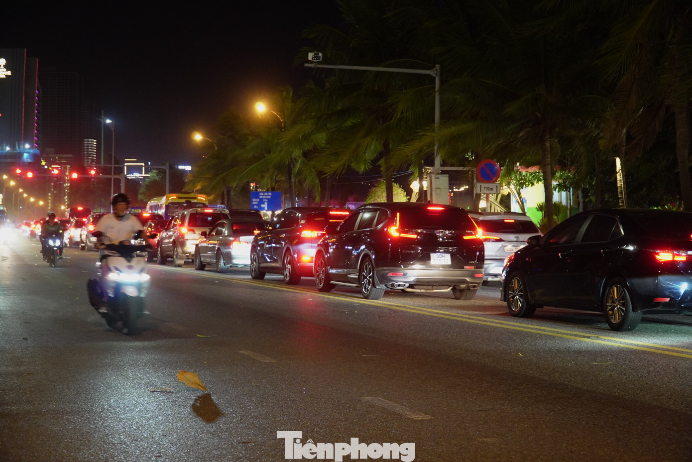 Xe ô tô, xe điện, xe máy chen chen chúc hỗn loạn giữa đường. Theo ghi nhận, từ 19h là thời điểm tuyến đường này bắt đầu ùn tắc. Anh Hải, nhân viên một bãi giữ xe gần đó cho hay các tối trong dịp lễ, đoạn đường biển đều xảy ra tình trạng này. "Họ không chỉ đi ăn uống mà ai cũng rời khách sạn để đi xem cầu Rồng phun lửa. Sau 21h đoạn đường này mới thông thoáng hơn", anh cho hay. Ảnh: Thanh Hiền.
