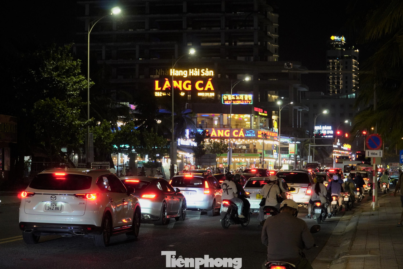 Xe ô tô, xe điện, xe máy chen chen chúc hỗn loạn giữa đường. Theo ghi nhận, từ 19h là thời điểm tuyến đường này bắt đầu ùn tắc. Anh Hải, nhân viên một bãi giữ xe gần đó cho hay các tối trong dịp lễ, đoạn đường biển đều xảy ra tình trạng này. "Họ không chỉ đi ăn uống mà ai cũng rời khách sạn để đi xem cầu Rồng phun lửa. Sau 21h đoạn đường này mới thông thoáng hơn", anh cho hay. Ảnh: Thanh Hiền.