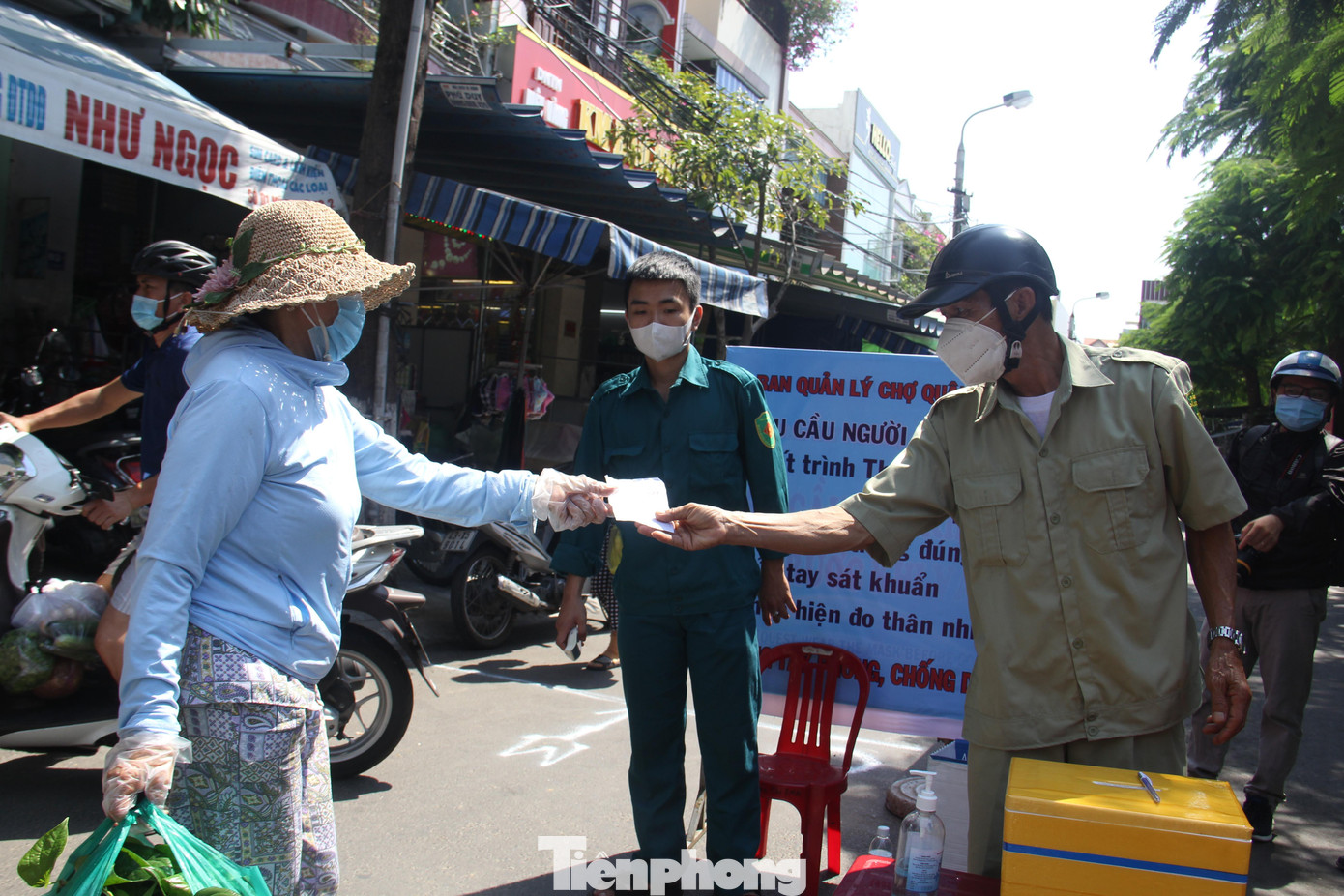 Người dân trước khi vào chợ đưa phiếu để lực lượng chức năng kiểm tra. Ảnh: Thanh Trần.