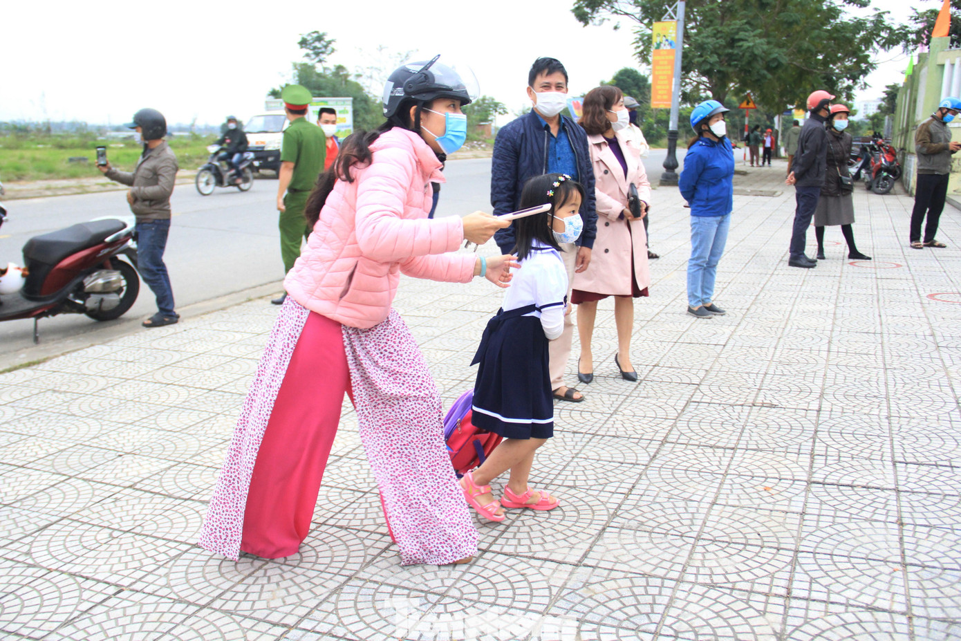 Các em học sinh lớp 1 được cha mẹ đưa tới trường từ sớm.