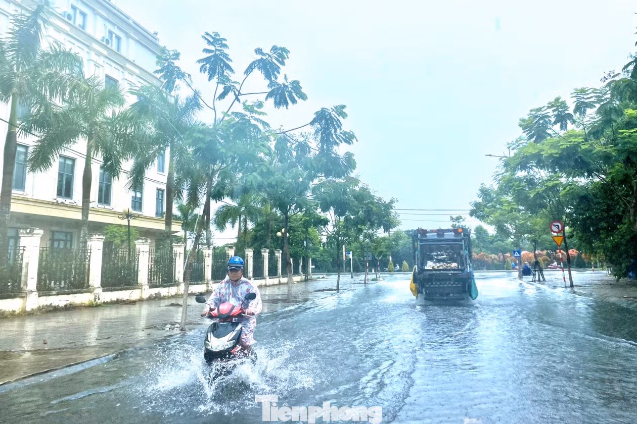 Một số tuyến đường ở trung tâm thành phố bì bõm nước, xe cộ nhích từng chút di chuyển trong cơn mưa. Ảnh: Thanh Hiền.