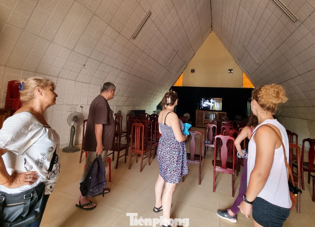 Một nhóm du khách nước ngoài xem phim tài liệu về địa đạo Vịnh Mốc.