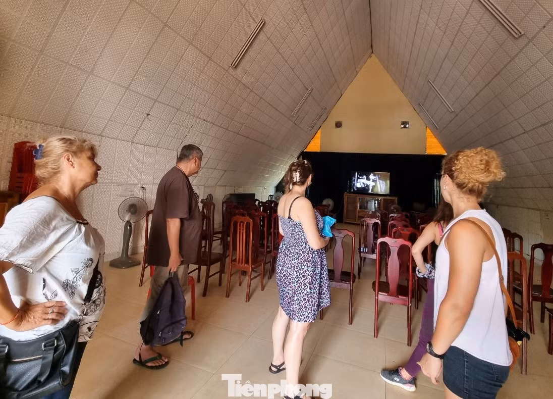 Một nhóm du khách nước ngoài xem phim tài liệu về địa đạo Vịnh Mốc.