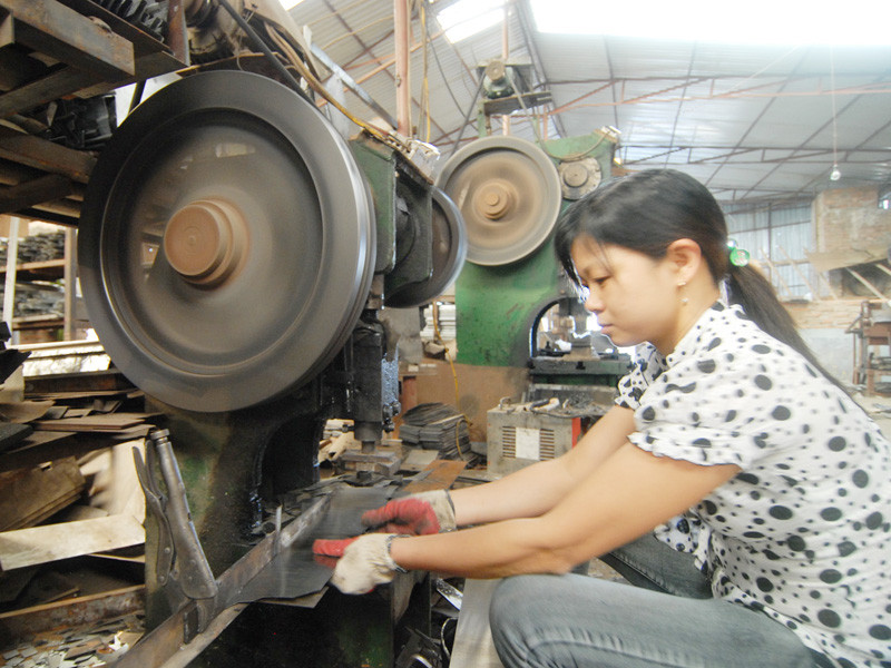 Một công nhân nữ làm đang cắt tôn trong Xưởng cơ khí, kim khí Việt Hàn. Một công nhân nữ làm đang cắt tôn trong Xưởng cơ khí, kim khí Việt Hàn