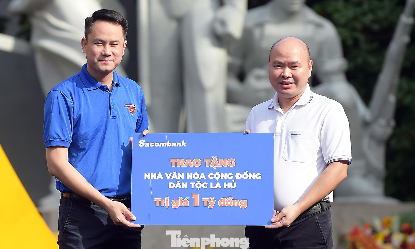 Đại diện Sacombank trao tặng biển tượng trưng kinh phí xây dựng nhà văn hóa cộng đồng dân tộc La Hủ. Ảnh: Xuân Tùng