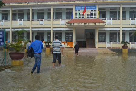 Giáo viên Cát Chánh cơ cực lội lũ giữa sân trường trong ngày 20.11. ảnh Việt Hương