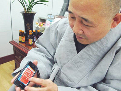 Hòa thượng Jung Ho đang mở một ứng dụng về triết lý Phật giáo trên điện thoại di động . Ảnh: Yonhap Hòa thượng Jung Ho đang mở một ứng dụng về triết lý Phật giáo trên điện thoại di động