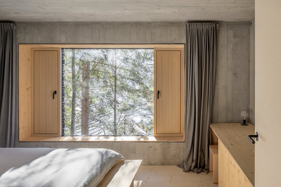 Hiên gỗ bên hông đóng vai trò như một khoảng sân trước và không gian sinh hoạt ngoài trời, kết nối liền mạch giữa nội thất bên trong với cảnh quan xung quanh.