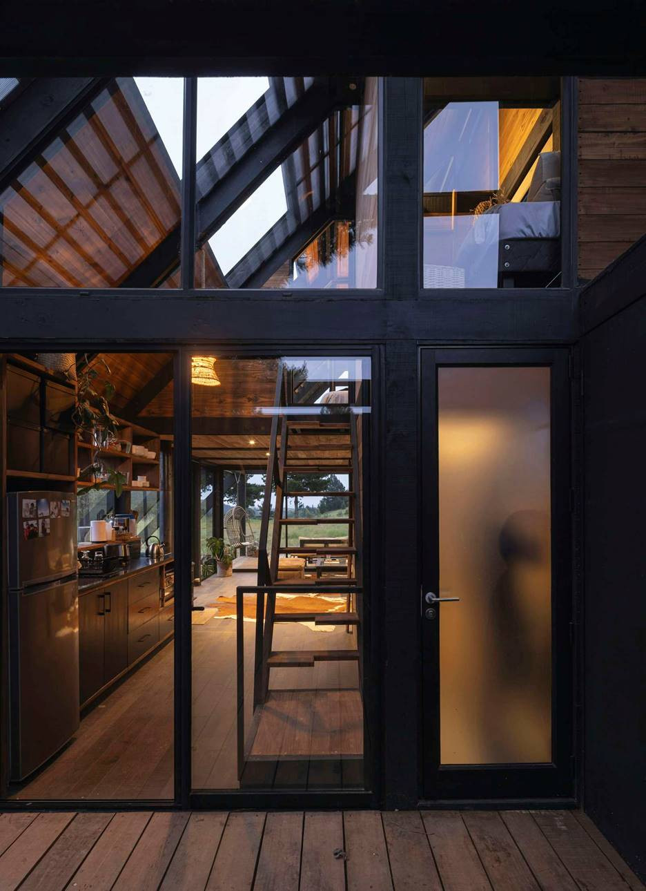 Cầu thang gỗ nổi nhẹ nhàng chia tách không gian, kết nối tầng trệt và gác lửng.