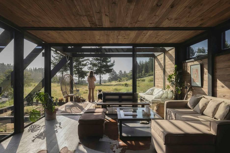 Toàn bộ căn nhà lát sàn gỗ trung tính, kết hợp ánh sáng tự nhiên từ ba mặt kính lớn mang lại cảm giác gần gũi và thư thái.