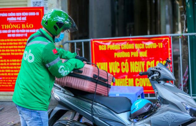 Người dân đang tiếp tế đồ dùng cá nhân cho những người bên trong khu vực phong tỏa Người dân đang tiếp tế đồ dùng cá nhân cho những người bên trong khu vực phong tỏa