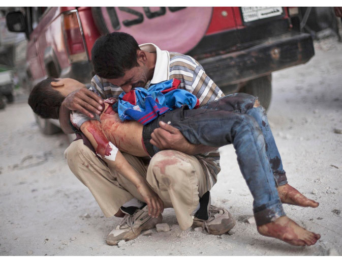 Một người đàn ông Syria đau khổ ôm xác con trai ở gần bệnh viện Dar El Shifa, thành phố Aleppo, Syria