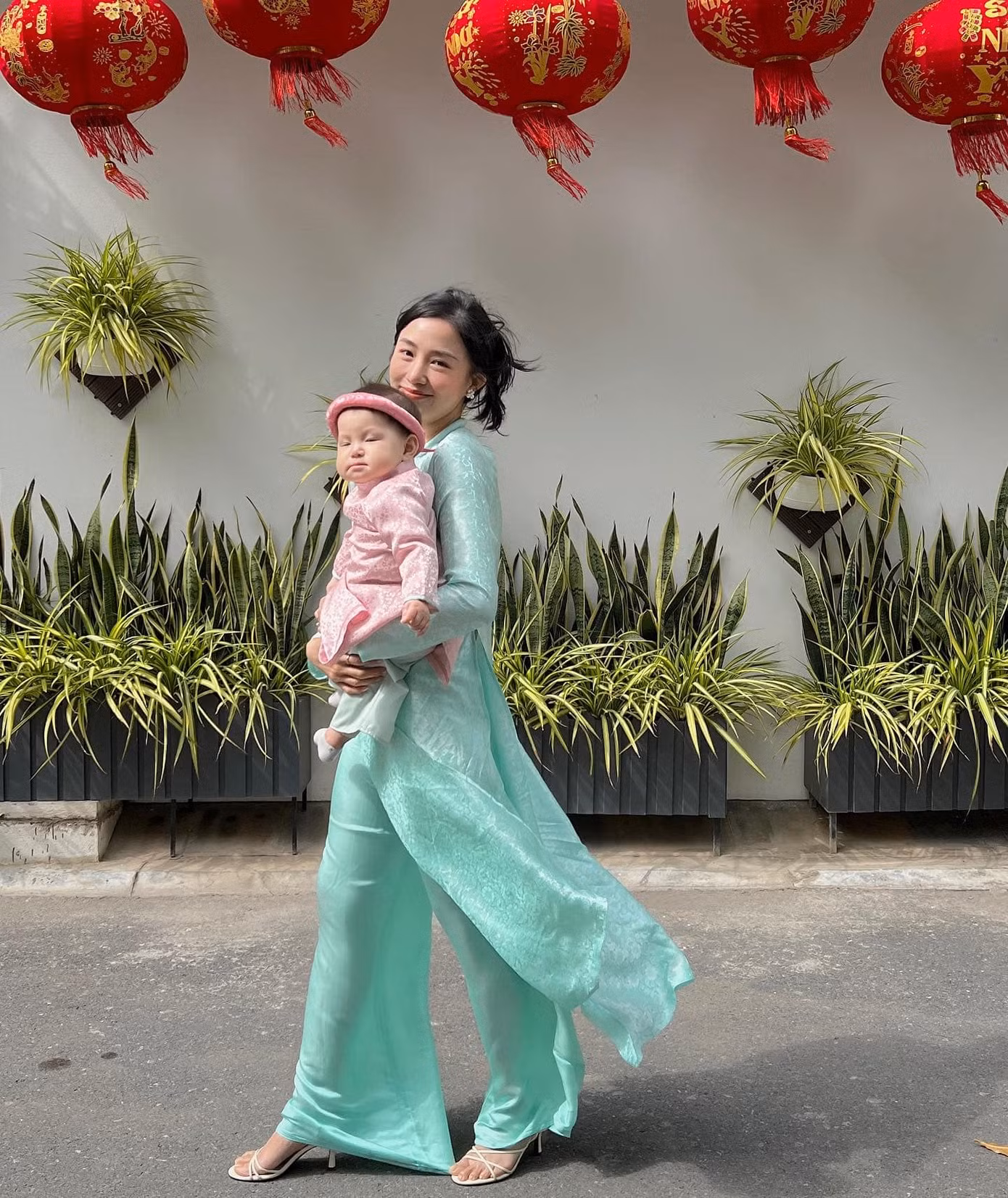 Hai bộ áo dài xanh và hồng tươi tắn cùng chất liệu lụa mềm mại khiến hai mẹ con người đẹp trông vô cùng dịu dàng, đằm thắm.
