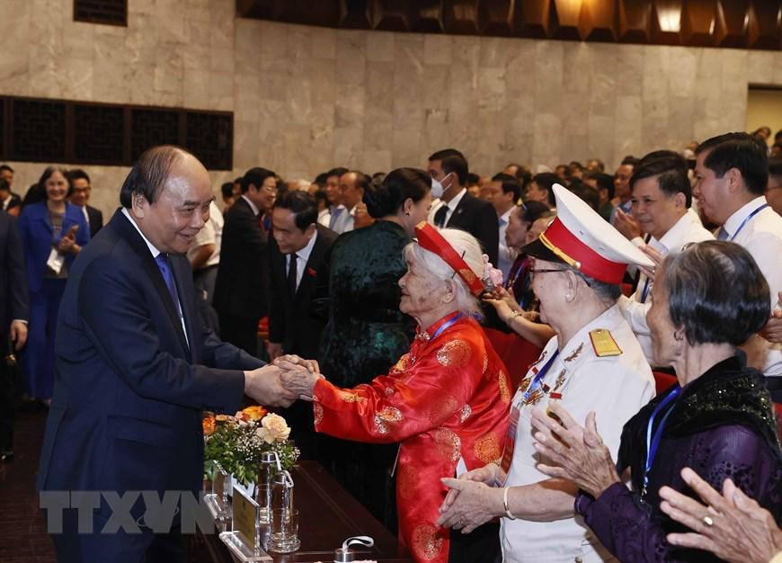 Chủ tịch nước Nguyễn Xuân Phúc với các Mẹ Việt Nam Anh hùng tại Lễ kỷ niệm. (Ảnh: Thống Nhất/TTXVN)