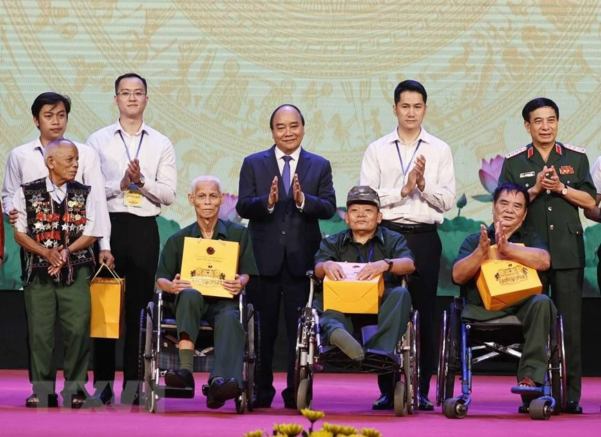Chủ tịch nước Nguyễn Xuân Phúc và Đại tướng, Bộ trưởng Quốc phòng Phan Văn Giang trao quà cho người có công và các thương bệnh binh. (Ảnh: Thống Nhất/TTXVN)