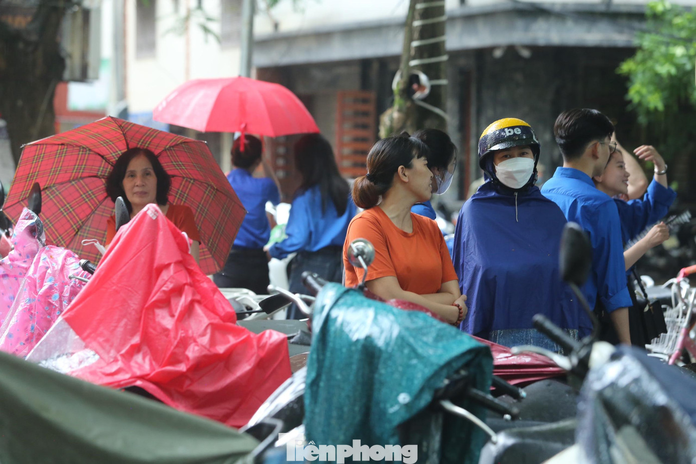 Phụ huynh đội mưa chờ thí sinh ngoài cổng trường. Phụ huynh đội mưa chờ thí sinh ngoài cổng trường.