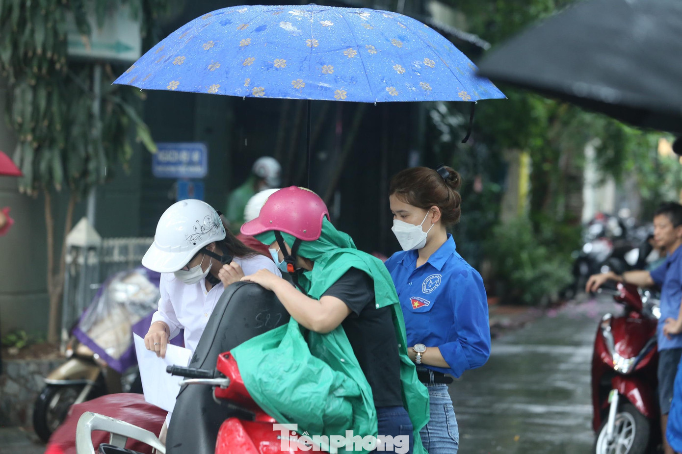 Các tình nguyện viên đến tận xe để che ô cho học sinh và phụ huynh. Các tình nguyện viên đến tận xe để che ô cho học sinh và phụ huynh.