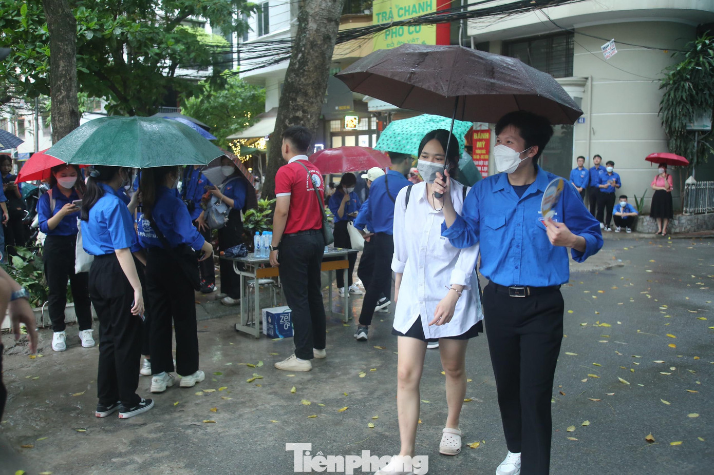 Áo xanh tình nguyện đội mưa che ô cho thí sinh từ cổng vào đến phòng thi trước giờ tập trung. Áo xanh tình nguyện đội mưa che ô cho thí sinh từ cổng vào đến phòng thi trước giờ tập trung.