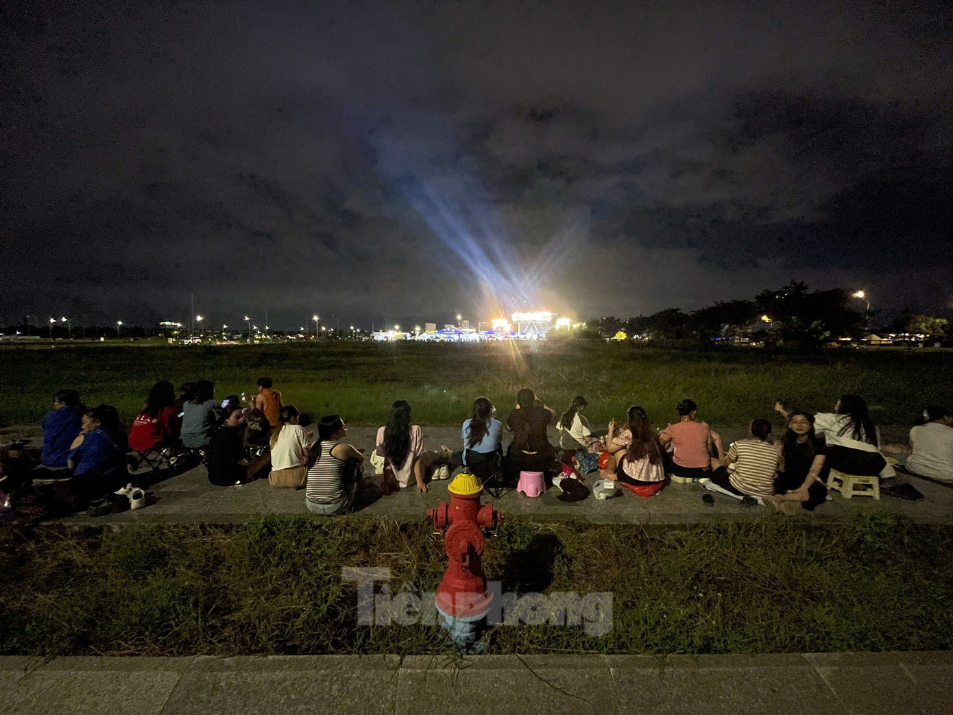 Với những người không có vé, họ chọn cách ngồi ngoài bãi cỏ hướng mắt theo dõi chương trình cách khoảng 300 m. Ảnh: Phạm Nguyễn. Với những người không có vé, họ chọn cách ngồi ngoài bãi cỏ hướng mắt theo dõi chương trình cách khoảng 300 m. Ảnh: Phạm Nguyễn.