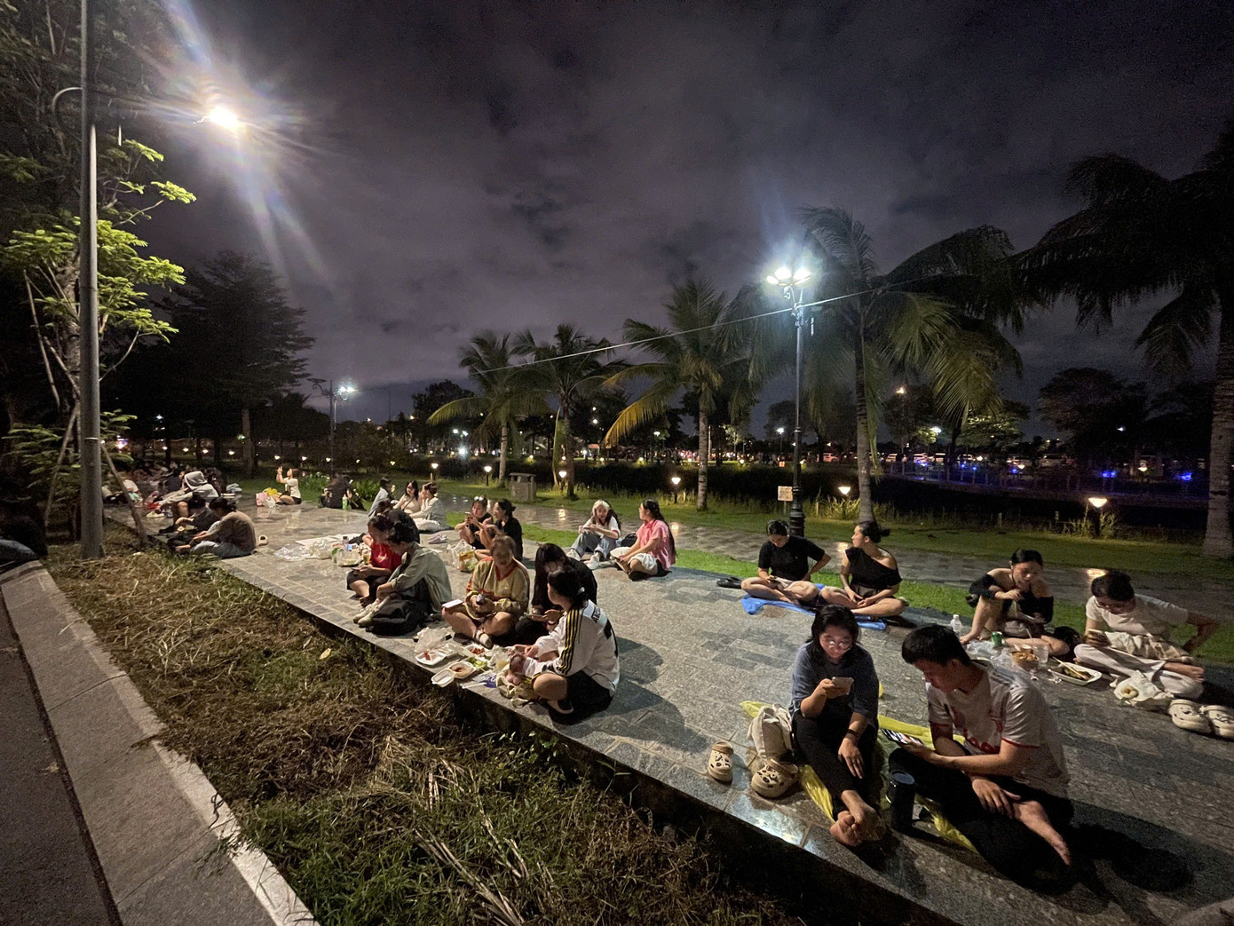 Với những người không có vé, họ chọn cách ngồi ngoài bãi cỏ hướng mắt theo dõi chương trình cách khoảng 300 m. Ảnh: Phạm Nguyễn. Với những người không có vé, họ chọn cách ngồi ngoài bãi cỏ hướng mắt theo dõi chương trình cách khoảng 300 m. Ảnh: Phạm Nguyễn.