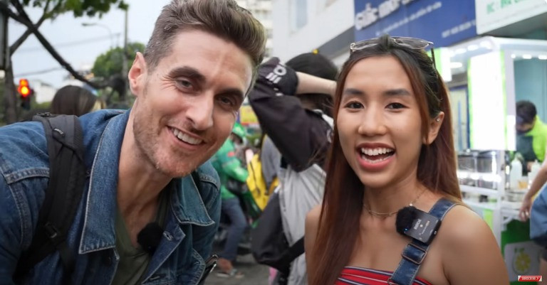 Dustin cùng cô bạn người Việt hào hứng xếp hàng chờ thưởng thức món trà chanh giã tay (Ảnh chụp màn hình)