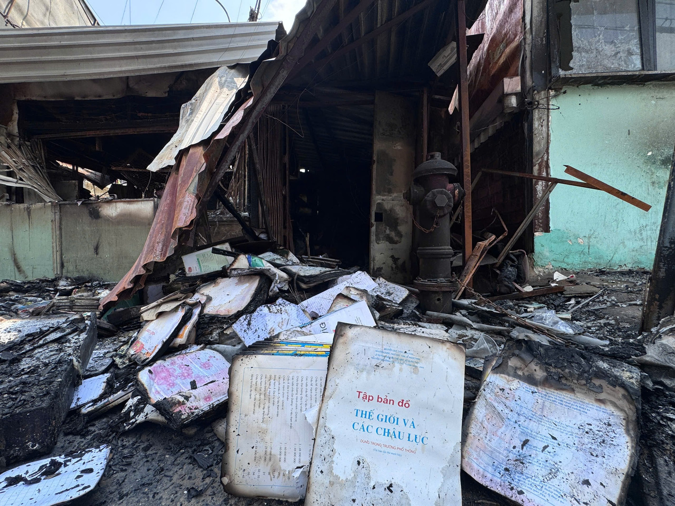 Sách vở, gấu bông, nệm mút, đồ chơi trẻ em, trái cây... bị cháy dang dở, nằm la liệt khắp các sạp.
