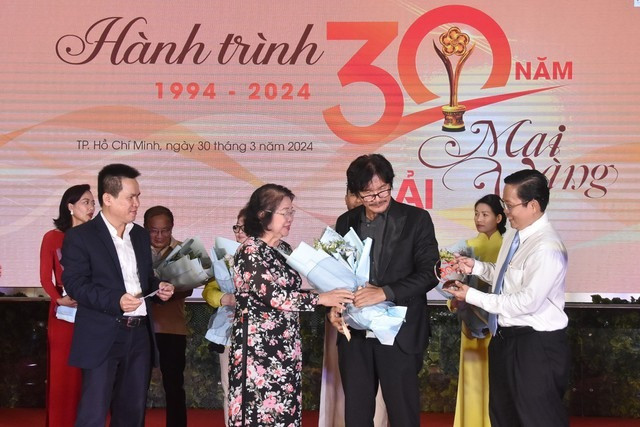 NSƯT Công Ninh nở nụ cười rạng rỡ khi nhận kỷ niệm chương và hoa. Nghệ sĩ nhớ lại lần đầu nhận tượng Mai Vàng năm 2000 nhờ vai Huy trong phim Đời cát, khiến anh vui mừng, hãnh diện. “Gala Hành trình 30 năm Giải Mai Vàng là sự vinh danh quý giá dành cho các nghệ sĩ. Tôi trân trọng BTC, cảm ơn đã mang đến cho tôi giải thưởng để đời, kỷ niệm đẹp trong cuộc đời làm nghệ thuật của tôi” - NSƯT Công Ninh chia sẻ.