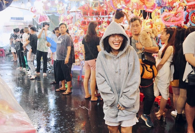 Nụ cười sảng khoái của một bạn trẻ khi ra giữa tuyến phố lúc trời mưa để chụp hình.