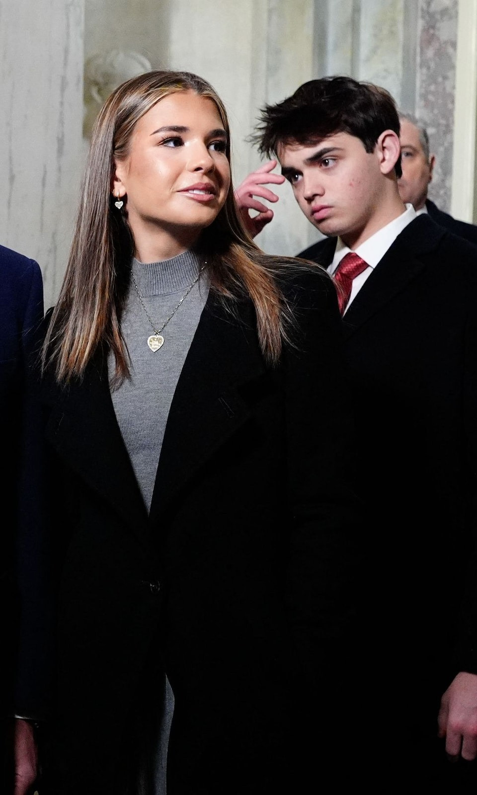 Cháu nội ông Trump - Kai Trump - diện váy len cổ lọ màu xám cho sự kiện. Cô khoác thêm chiếc áo dáng dài màu đen với điểm nhấn là chiếc cúc cài duy nhất ở giữa. Về phụ kiện, Kai kết hợp cùng dây chuyền vàng với mặt dây hình trái tim tinh tế và để tóc thẳng, tạo nên vẻ ngoài trang nhã và hiện đại.