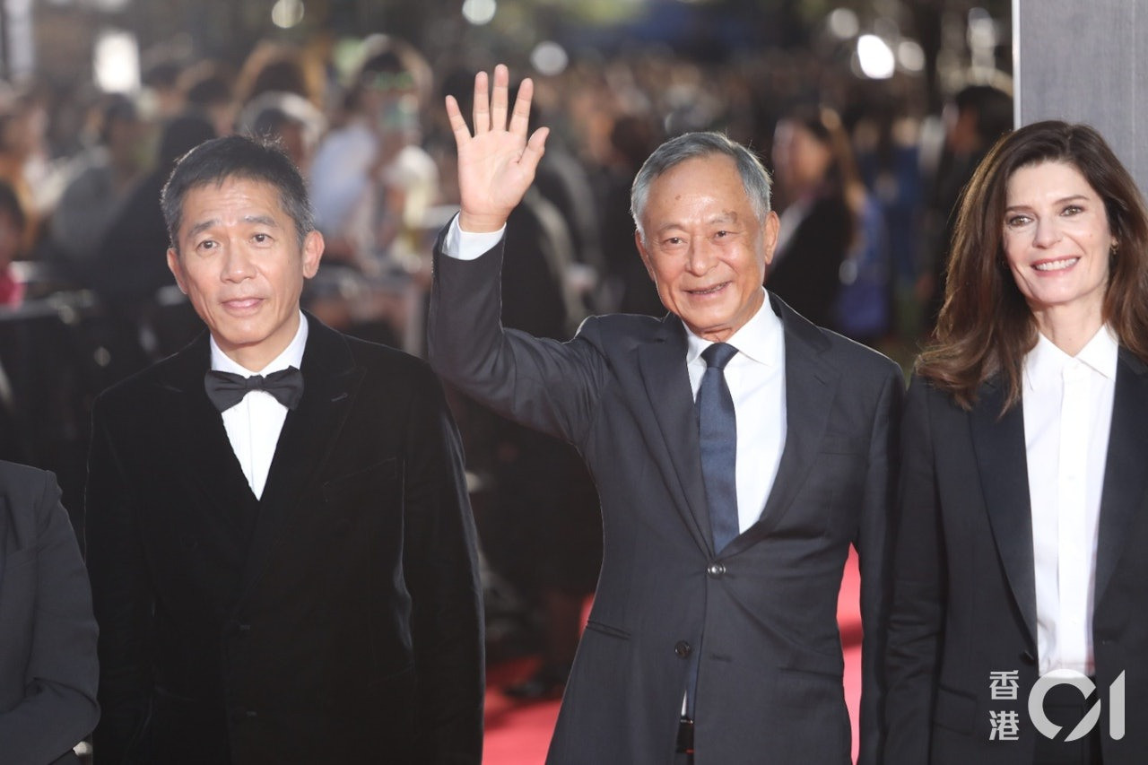 Lương Triều Vỹ (bìa trái) và đạo diễn Đỗ Kỳ Phong (giữa) vẫy chào người hâm mộ. Nhiều năm nay, Lương Triều Vỹ là khách thường xuyên của LHP quốc tế Tokyo. Ảnh: HK01.