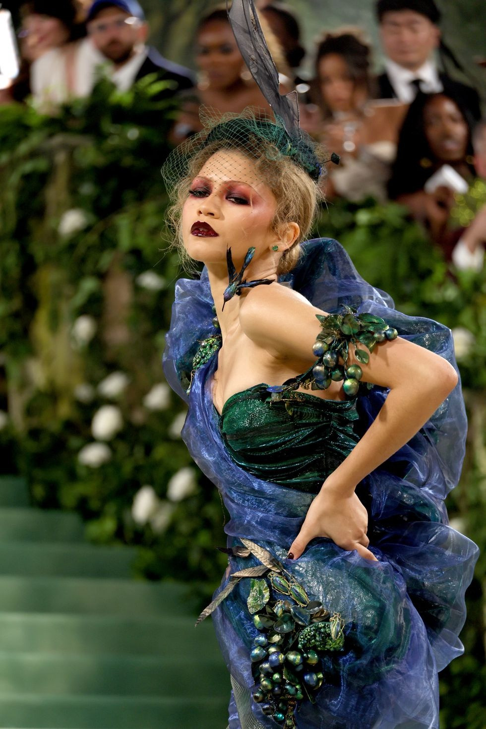 Zendaya xuất hiện ấn tượng với đôi môi sẫm màu và đội mũ lông vũ. Người chủ trì sự kiện được ví như con công với các sắc thái xanh lá cây, tím và xanh lam. Chiếc váy mang phong cách cổ điển của Christian Dior, từ bộ sưu tập thời trang mùa xuân năm 1999 do John Galliano thiết kế.