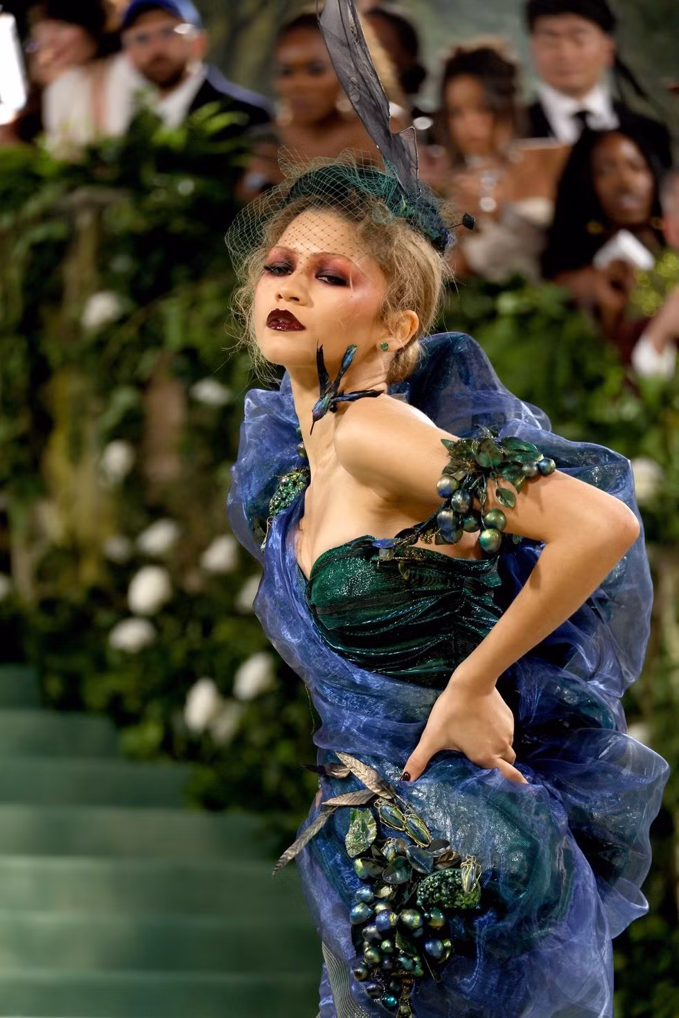 Zendaya xuất hiện ấn tượng với đôi môi sẫm màu và đội mũ lông vũ. Người chủ trì sự kiện được ví như con công với các sắc thái xanh lá cây, tím và xanh lam. Chiếc váy mang phong cách cổ điển của Christian Dior, từ bộ sưu tập thời trang mùa xuân năm 1999 do John Galliano thiết kế.