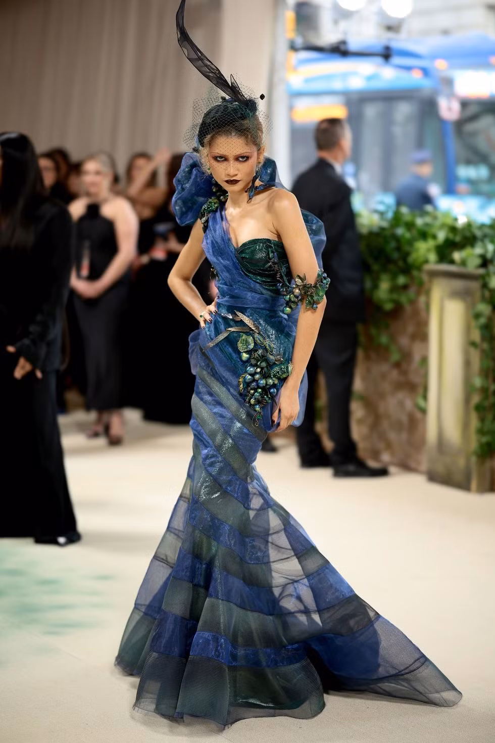 Zendaya xuất hiện ấn tượng với đôi môi sẫm màu và đội mũ lông vũ. Người chủ trì sự kiện được ví như con công với các sắc thái xanh lá cây, tím và xanh lam. Chiếc váy mang phong cách cổ điển của Christian Dior, từ bộ sưu tập thời trang mùa xuân năm 1999 do John Galliano thiết kế.