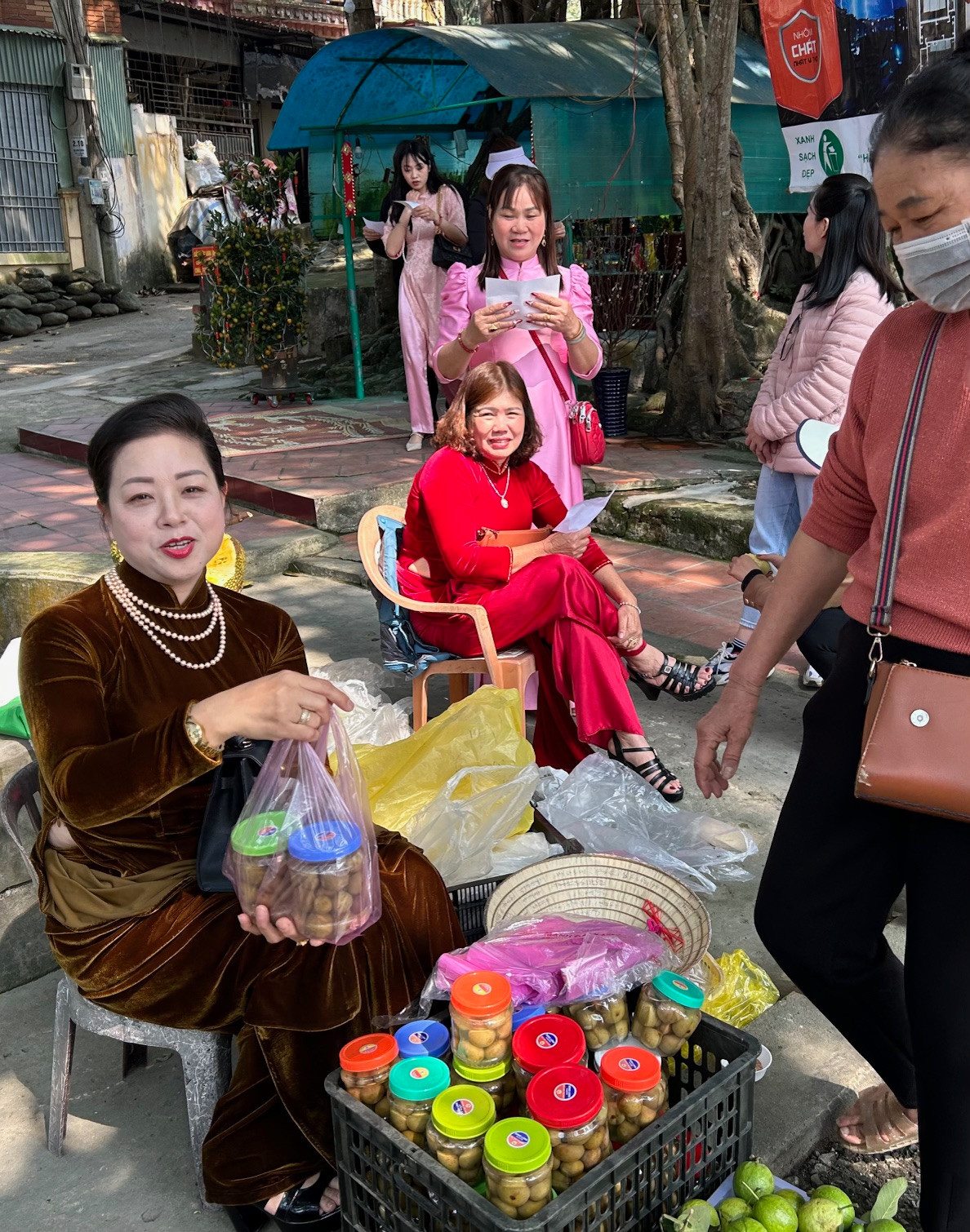 Chị có vẻ đẹp sắc sảo trong trong bộ áo dài nhung tuyết nâu vàng ánh kim với phụ kiện là những vòng ngọc trai, hoa tai và những chiếc nhẫn vàng, trang điểm khá đậm.