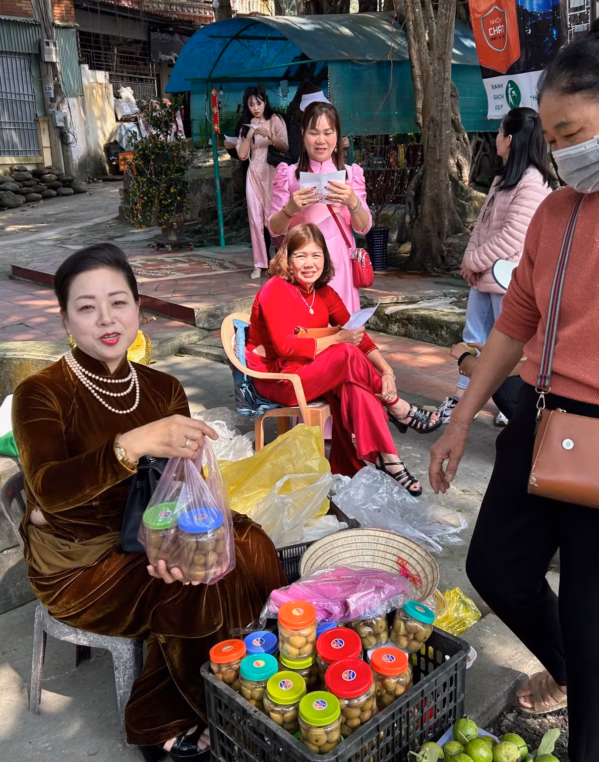 Chị có vẻ đẹp sắc sảo trong trong bộ áo dài nhung tuyết nâu vàng ánh kim với phụ kiện là những vòng ngọc trai, hoa tai và những chiếc nhẫn vàng, trang điểm khá đậm. Chị có vẻ đẹp sắc sảo trong trong bộ áo dài nhung tuyết nâu vàng ánh kim với phụ kiện là những vòng ngọc trai, hoa tai và những chiếc nhẫn vàng, trang điểm khá đậm.
