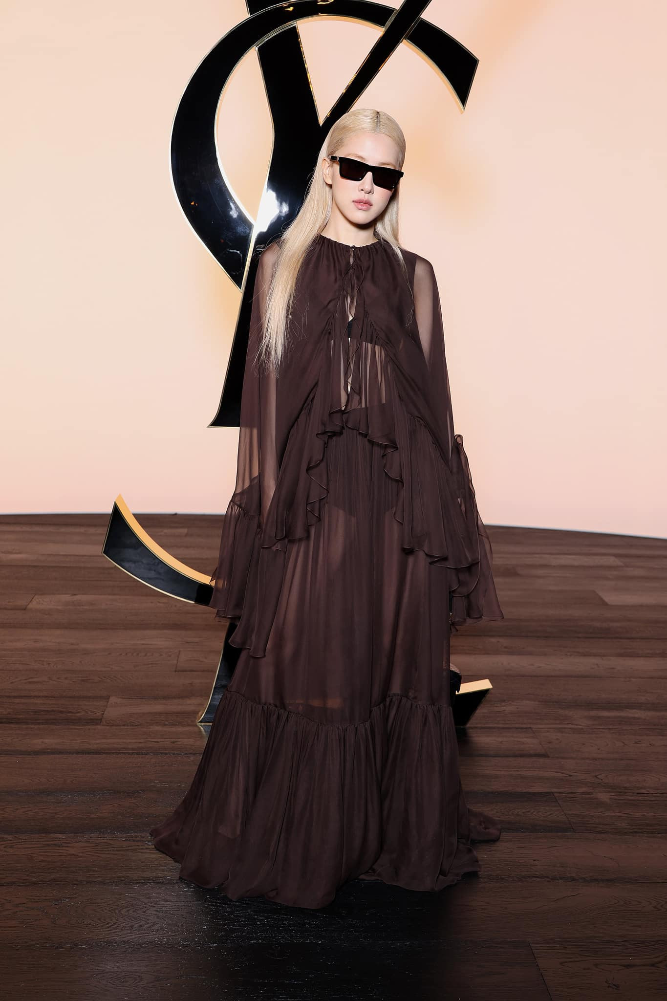 Tại show diễn của Saint Laurent, Rosé (BlackPink) chọn đầm xếp tầng tối màu, xuyên thấu để lộ nội y. Tại show diễn của Saint Laurent, Rosé (BlackPink) chọn đầm xếp tầng tối màu, xuyên thấu để lộ nội y.